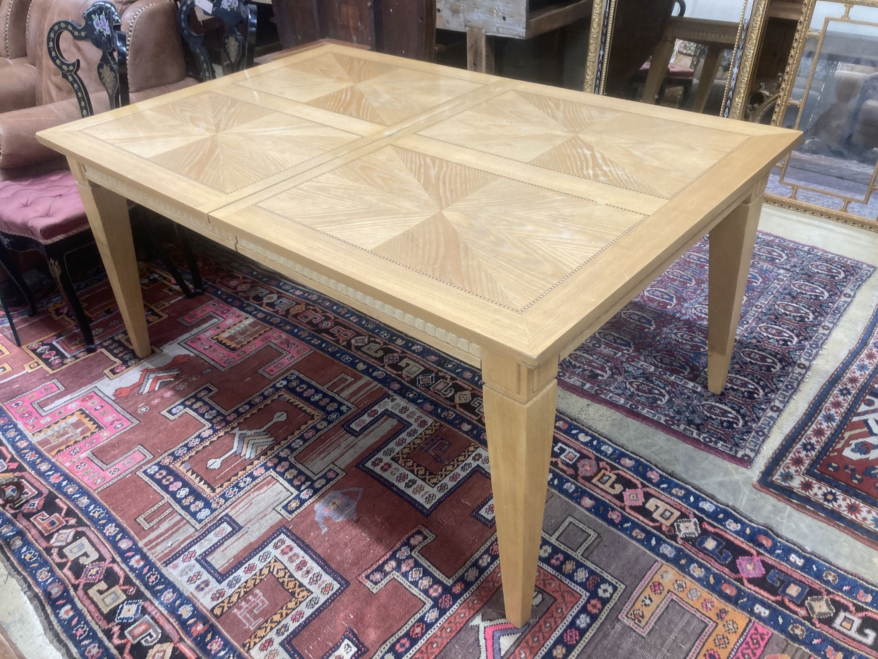 A contemporary inlaid oak extending dining table, 236cm extended, two spare leaves, W.106cm H.75cm